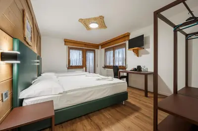 a bedroom with a bed in a wooden room at Nord Hotel in Cortina dʼAmpezzo