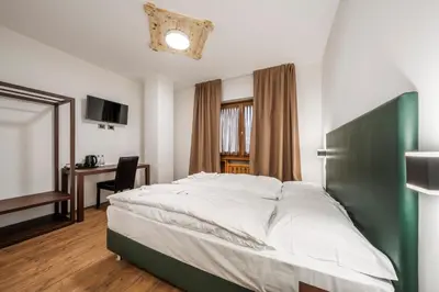 a large wooden bed in a bedroom with a wooden ceiling at Nord Hotel in Cortina dʼAmpezzo