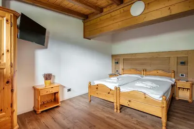 a living room with chairs and tables and windows at Nord Hotel in Cortina dʼAmpezzo