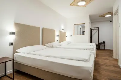 a bedroom with a wooden bed with a wooden headboard at Nord Hotel in Cortina dʼAmpezzo
