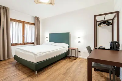 a room with three beds and a door open at Nord Hotel in Cortina dʼAmpezzo