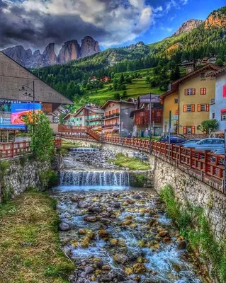 a river in a town with mountains in the background at Cèsa Mia in Campitello di Fassa