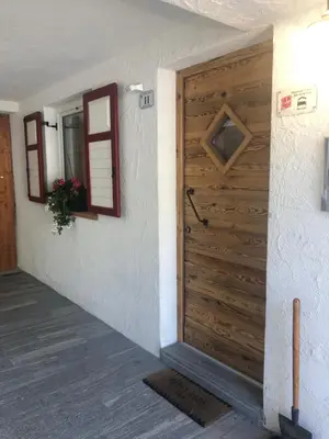 a wooden door in a room with a wall at Cèsa Mia in Campitello di Fassa