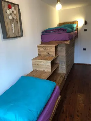 a bedroom with two twin beds and wooden drawers at Cèsa Mia in Campitello di Fassa