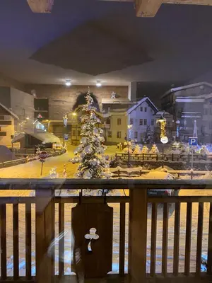 a christmas tree on a balcony with a toy town at Cèsa Mia in Campitello di Fassa