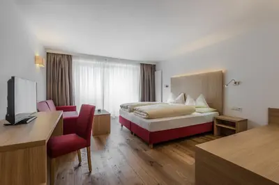 a hotel room with a bed and a desk at Hotel Miramonti Badia in Badia