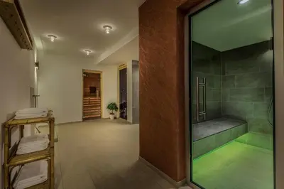 a bathroom with a tub and a shower with a glass door at Hotel Miramonti Badia in Badia