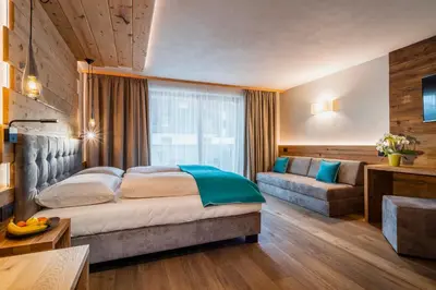 a hotel room with a bed and a couch at Garni Mia Co in Antermoia