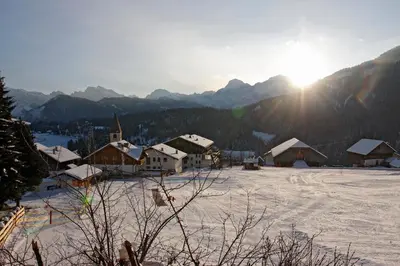 a snow covered village with mountains in the background at Garni Mia Co in Antermoia