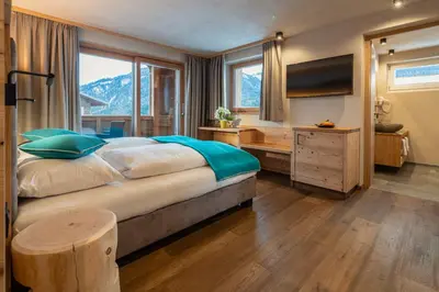 a bedroom with a large bed and a television at Garni Mia Co in Antermoia