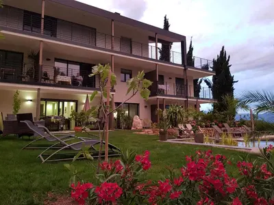 a view of a building with flowers in the yard at Gartenappartements Die Mühle - ADULTS ONLY in Caldaro