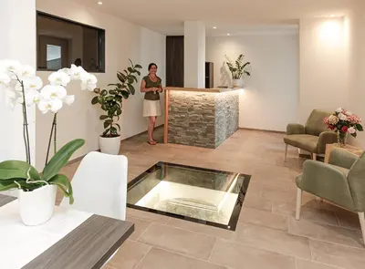 a woman is standing in a living room at Gartenappartements Die Mühle - ADULTS ONLY in Caldaro