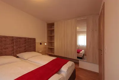 a bedroom with a bed with a red blanket on it at Gartenappartements Die Mühle - ADULTS ONLY in Caldaro