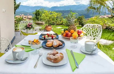 a table with plates of food and cups of coffee at Gartenappartements Die Mühle - ADULTS ONLY in Caldaro