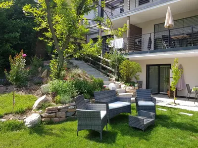 a patio with chairs and a table in a yard at Gartenappartements Die Mühle - ADULTS ONLY in Caldaro