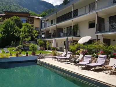 a hotel with chairs and a swimming pool at Gartenappartements Die Mühle - ADULTS ONLY in Caldaro