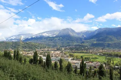 a town on a hill with mountains in the background at B&B - Apartments Sunnwies in Marlengo