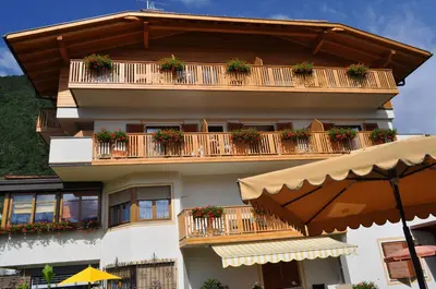 a building with potted plants on the balconies at B&B - Apartments Sunnwies in Marlengo