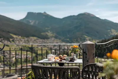 a room with a bed with a view of mountains at Hotel Niblea Dolomites in Ortisei