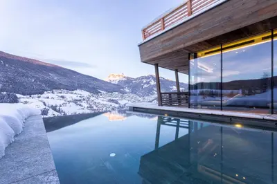 a bedroom with a bed with a view of a mountain at Hotel Niblea Dolomites in Ortisei