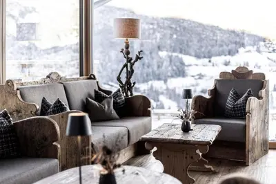 a bedroom with a bed and a living room at Hotel Niblea Dolomites in Ortisei
