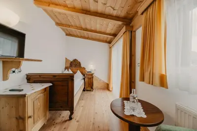 a kitchen with a table and a wooden ceiling at Hotel Garni Planaces in Ortisei