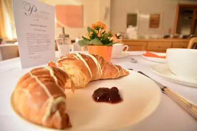 a plate with a croissant and jam on a table at Hotel Garni Planaces in Ortisei