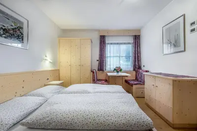 a bedroom with three beds and a window at Residence Costa Burjada in Colfosco