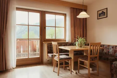 a dining room with a table and chairs and a window at Residence Costa Burjada in Colfosco