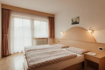 a bedroom with a large bed and a window at Residence Costa Burjada in Colfosco