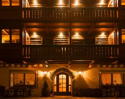 a lit up building with a deck on top at night at Garni Hotel Geier in Santa Cristina in Val Gardena