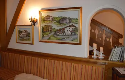 a room with two pictures of houses on the wall at Hotel Stella Alpina in Bellamonte
