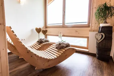 a wooden hammock in a room with a window at Tallnerhof in Schenna