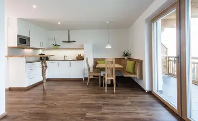 a kitchen and dining room with a table and chairs at Tallnerhof in Schenna