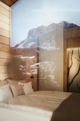 a bedroom with a bed with a painting on the wall at Hotel La Müda in Badia