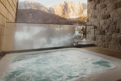 a jacuzzi tub with a view of a mountain at Hotel La Müda in Badia
