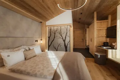 a bedroom with a bed with a tree mural on the wall at Hotel La Müda in Badia