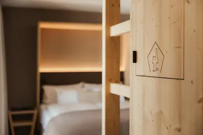 a bedroom with a bunk bed with a bed sqor at Hotel La Müda in Badia
