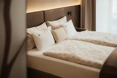 a bedroom with a bed with white pillows at Hotel La Müda in Badia