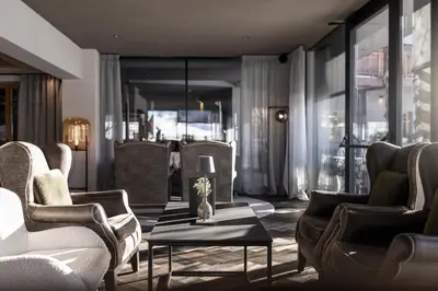 a lobby with chairs and a table with a lamp at Hotel Viertler in Avelengo