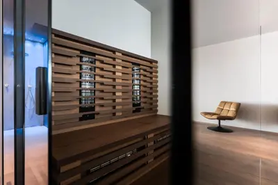 a bedroom with a wooden wall and a chair at Hotel Viertler in Avelengo