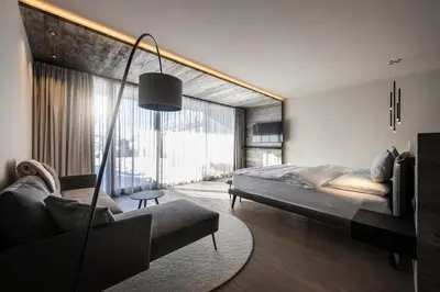 a bedroom with a large bed and a couch at Hotel Viertler in Avelengo