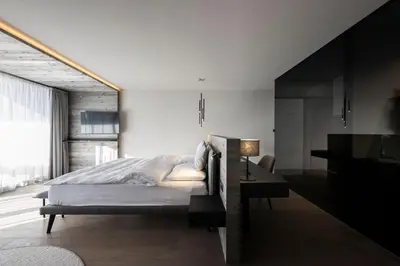 a bedroom with a bed and a desk with a lamp at Hotel Viertler in Avelengo