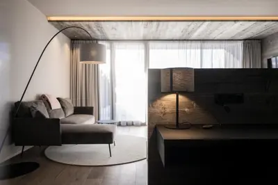 a living room with a couch and a lamp at Hotel Viertler in Avelengo