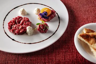 a white plate with some food on a table at Boutique Hotel Nives - Luxury & Design in the Dolomites in Selva di Val Gardena