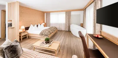 a hotel room with a bed and a tv at Boutique Hotel Nives - Luxury & Design in the Dolomites in Selva di Val Gardena