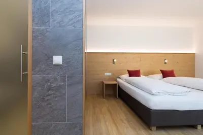 a bedroom with a bed and a shower at Garni Bachlerhof in Brunico