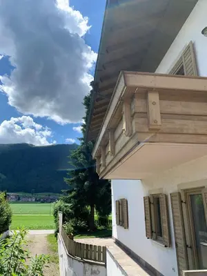 a white house with a view of a green field at Appartments Hilber in Brunico