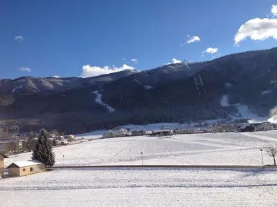a snow covered field with mountains in the background at Appartments Hilber in Brunico