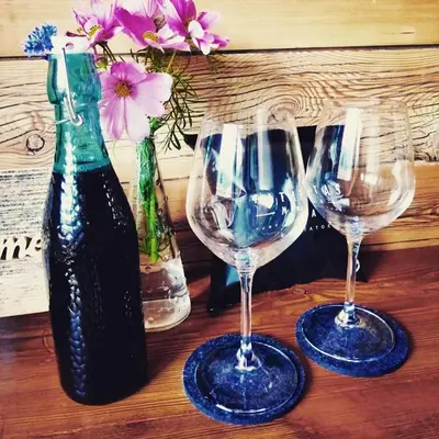 three wine glasses and a bottle on a wooden table at Casa de Fiemme in Tesero